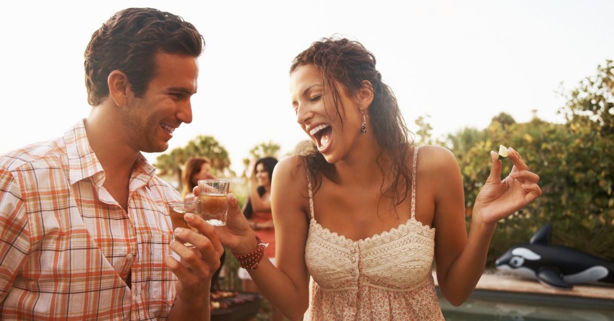 A  young couple having tequila shots.