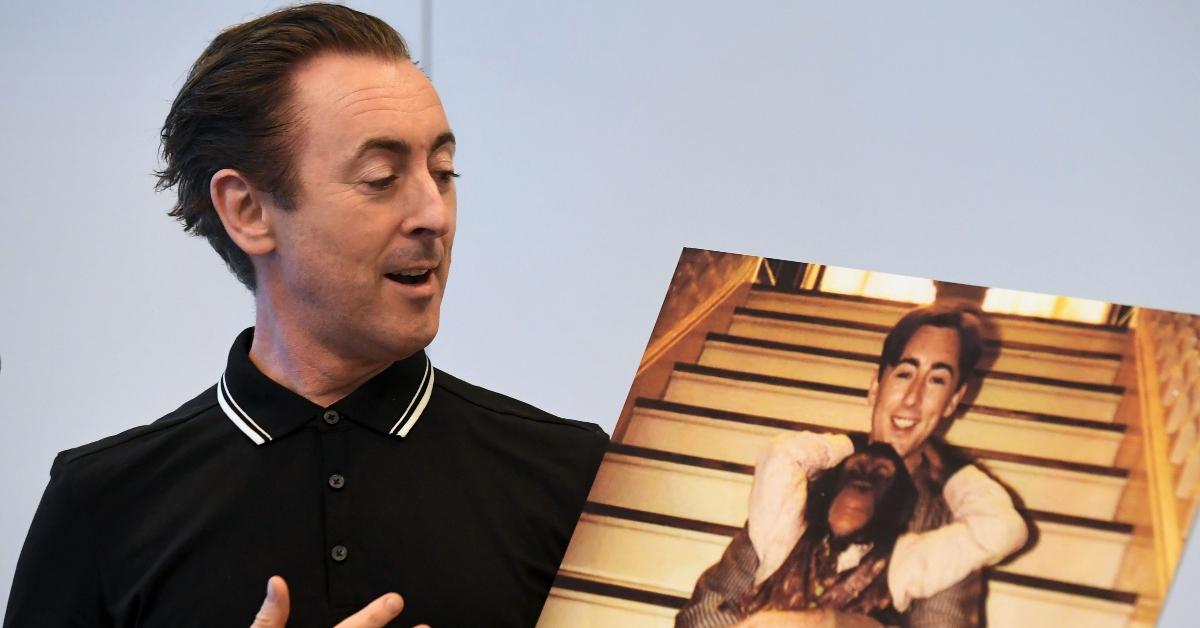 Alan Cumming holds up a photo of him and Tonka on the set of 'Buddy'