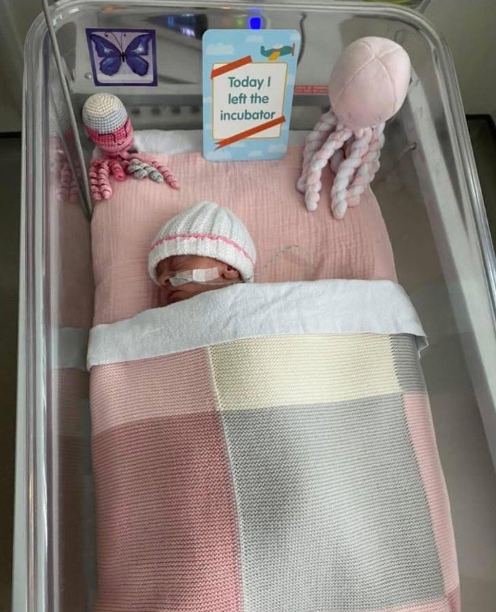 Purple butterfly sticker sits next to a newborn.