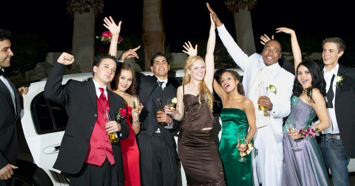 A group of friends outside a limo in prom attire