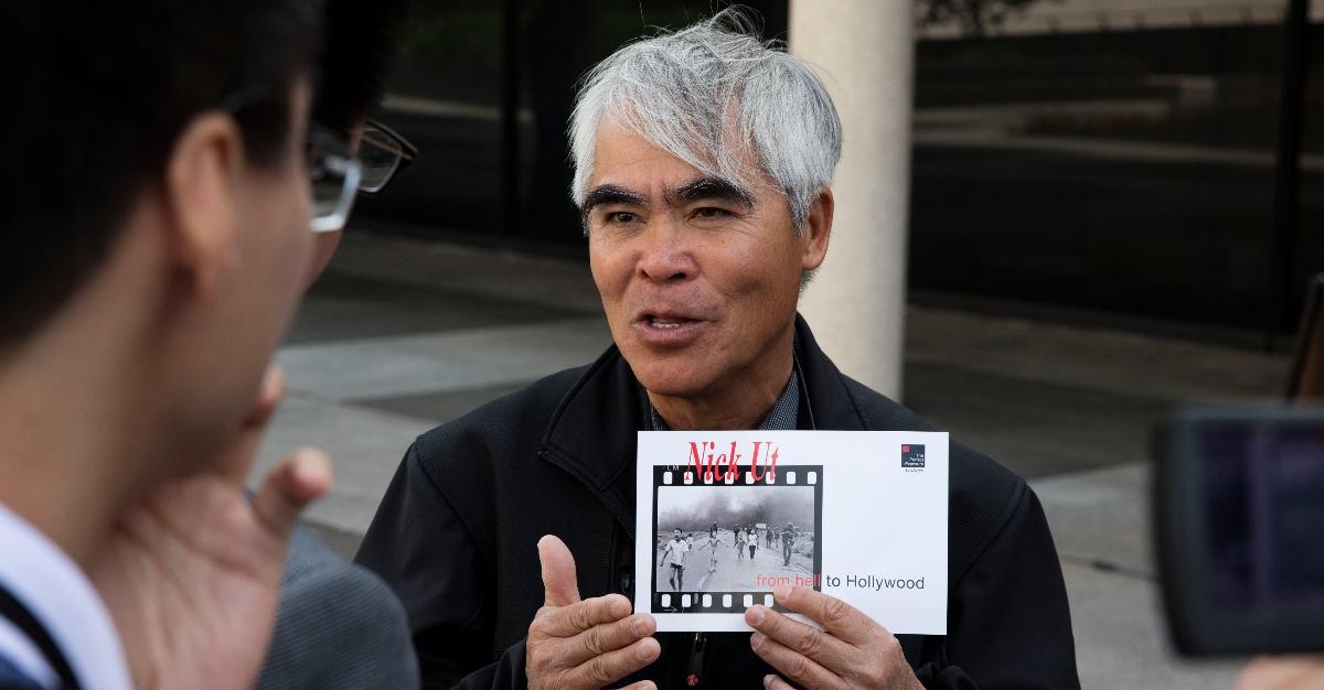 Photographer Nick Ut holds up a photo of Napalm Girl which he allegedly took