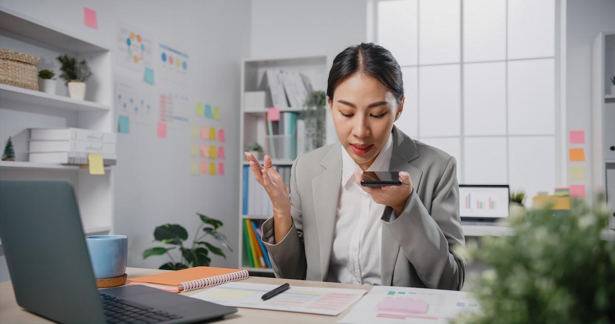 A corporate boss at her desk on her phone