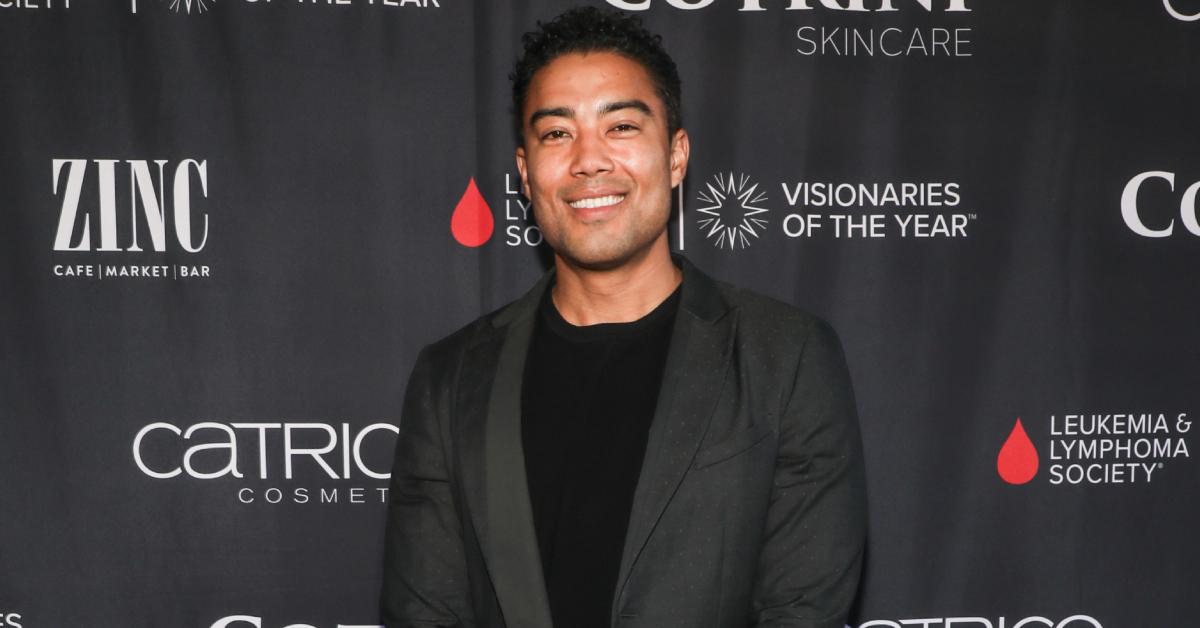 Jason Caperna smiles and poses in a sleek, black suit on the red carpet at the Sparkle's Drag Spectacular on April 27, 2024 in North Hollywood.