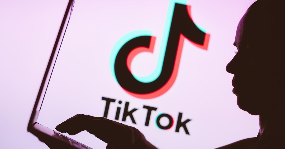 Silhouette of person on laptop with TikTok logo