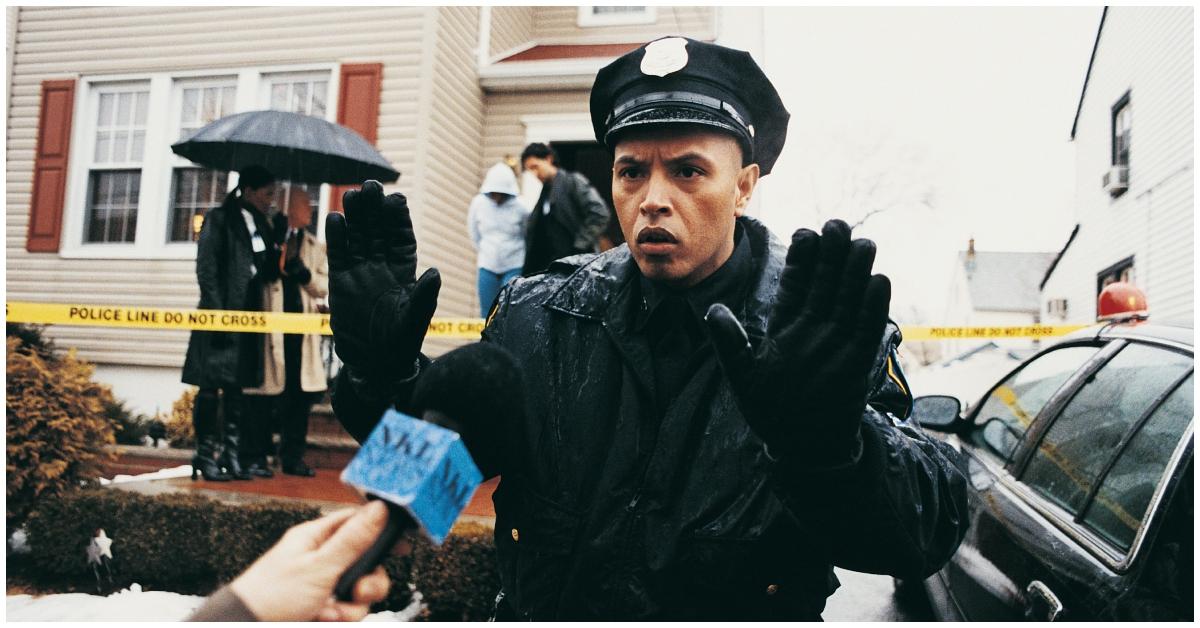 A police officer speaking to a reporter during an arrest