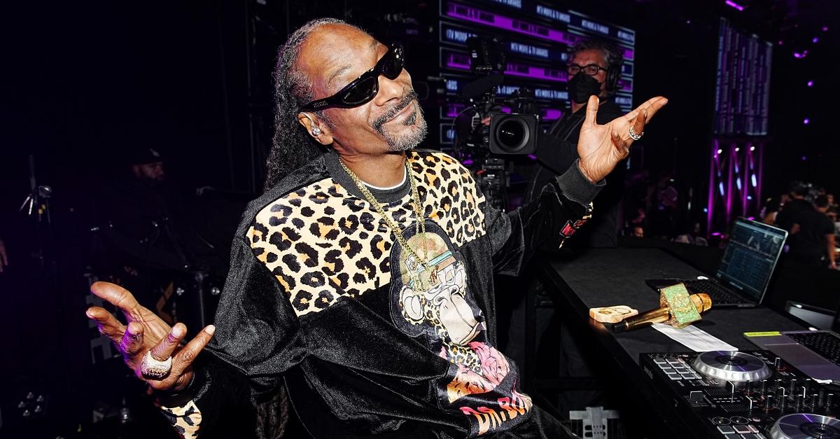Snoop Dogg wears a velvet and cheetah print sweatshirt and dark sunglasses.