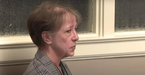 Annette Cahill looking somber in a gray plaid suit