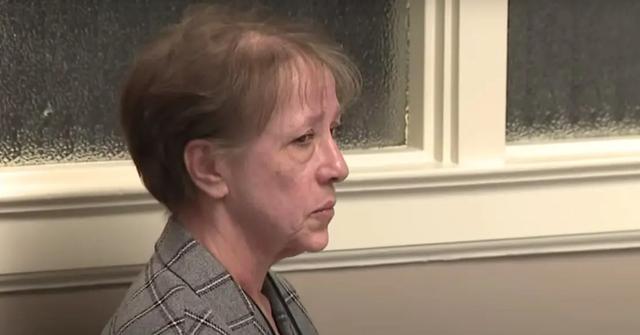 Annette Cahill looking somber in a gray plaid suit