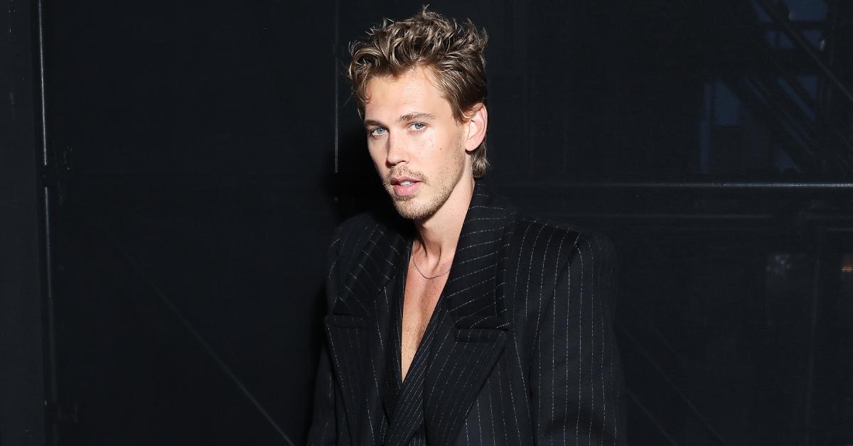 Austin Butler wearing a black stripe suit to the Saint Laurent womenswear spring/summer 2024 show.