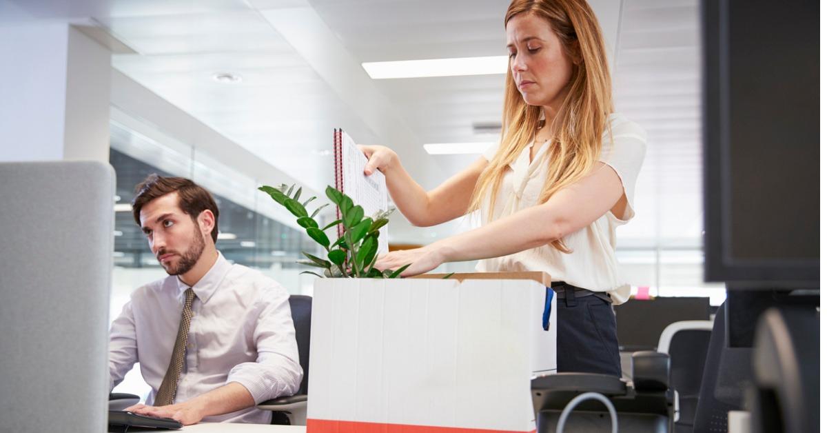 fired female employee packing box of belongings in an office picture id