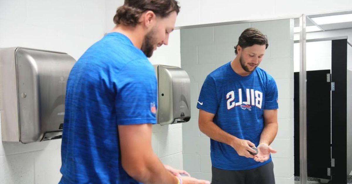 Josh Allen shaving in a bathroom mirror. 