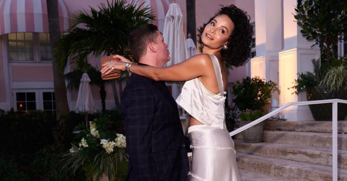 Sai De Silva in a white silk outfit and her husband in a suit.