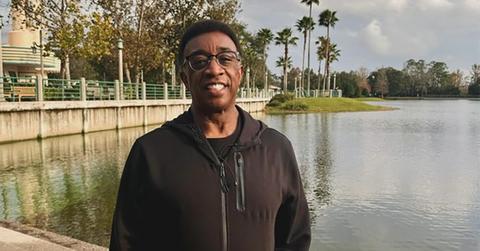 Wayne Dawson wearing a hoodie and standing next to a body of water.