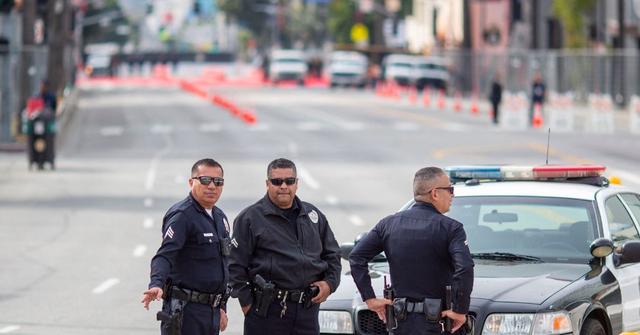 Police officers stand outside of the Oscars red carpet in the road