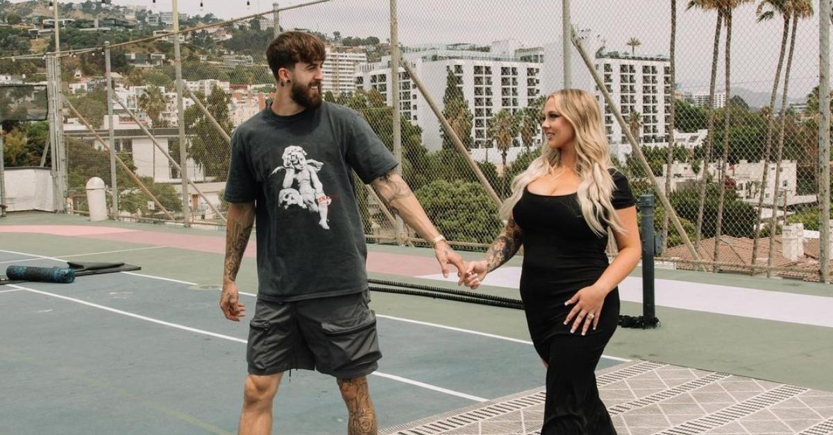 Sean Austin and Jade Cline hold hands on a tennis court