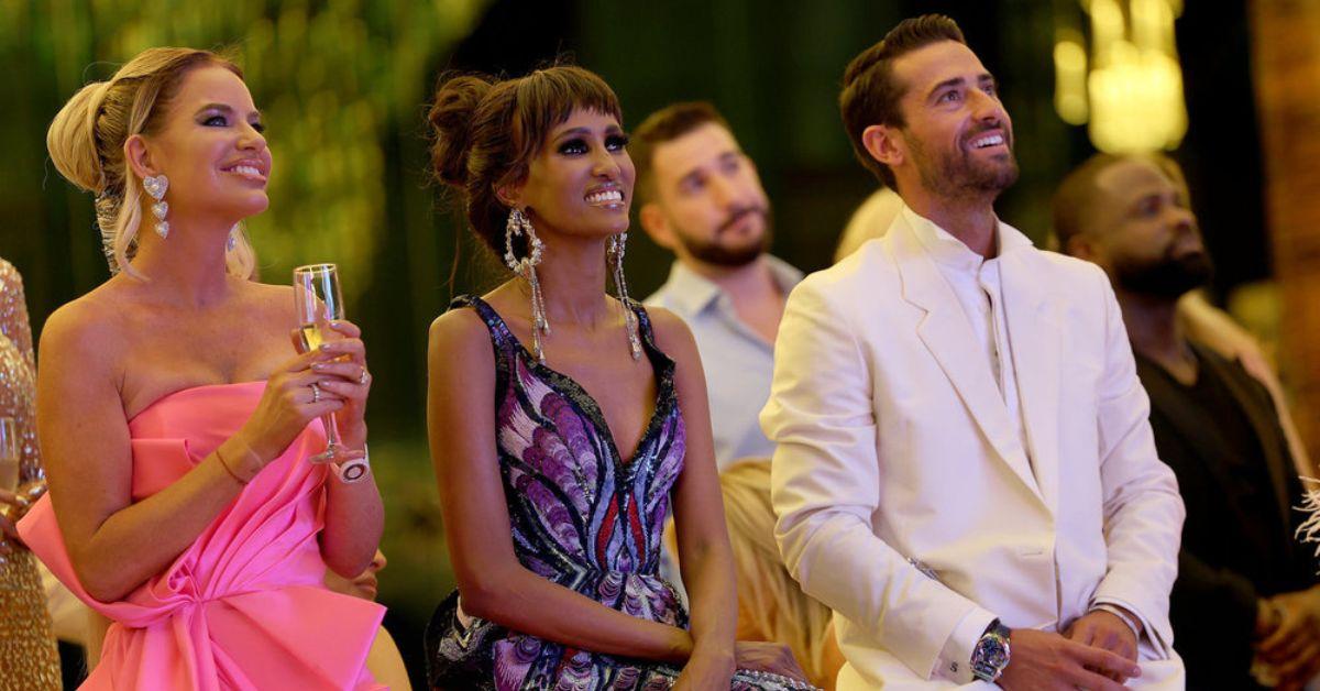 Caroline Stanbury, Chanel Ayan, and Sergio Carrallo seated at an event watching something off camera on 'RHODubai'