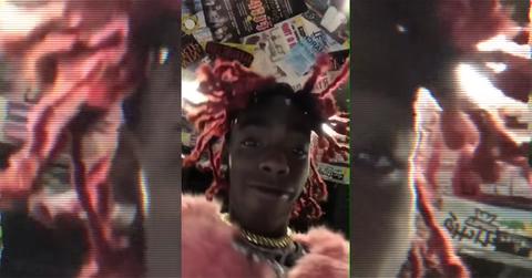 YNW Melly with pink hair looking down at the camera.