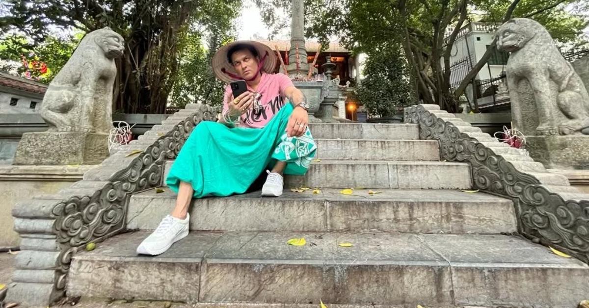 Zubeen Garg sits on steps outside.