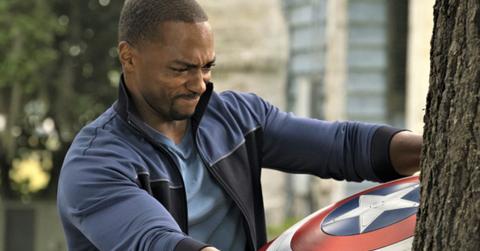 Sam Wilson struggles to pull Captain America's shield out of a tree.