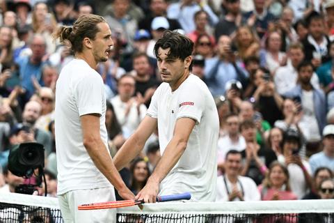 Winner US player Taylor Fritz (R) speaks with Germany's Alexander Zverev at the end of their men's singles tennis match on the eighth day of the 2024 Wimbledon Championships at The All England Lawn Tennis and Croquet Club in Wimbledon, southwest London, on July 8, 2024.