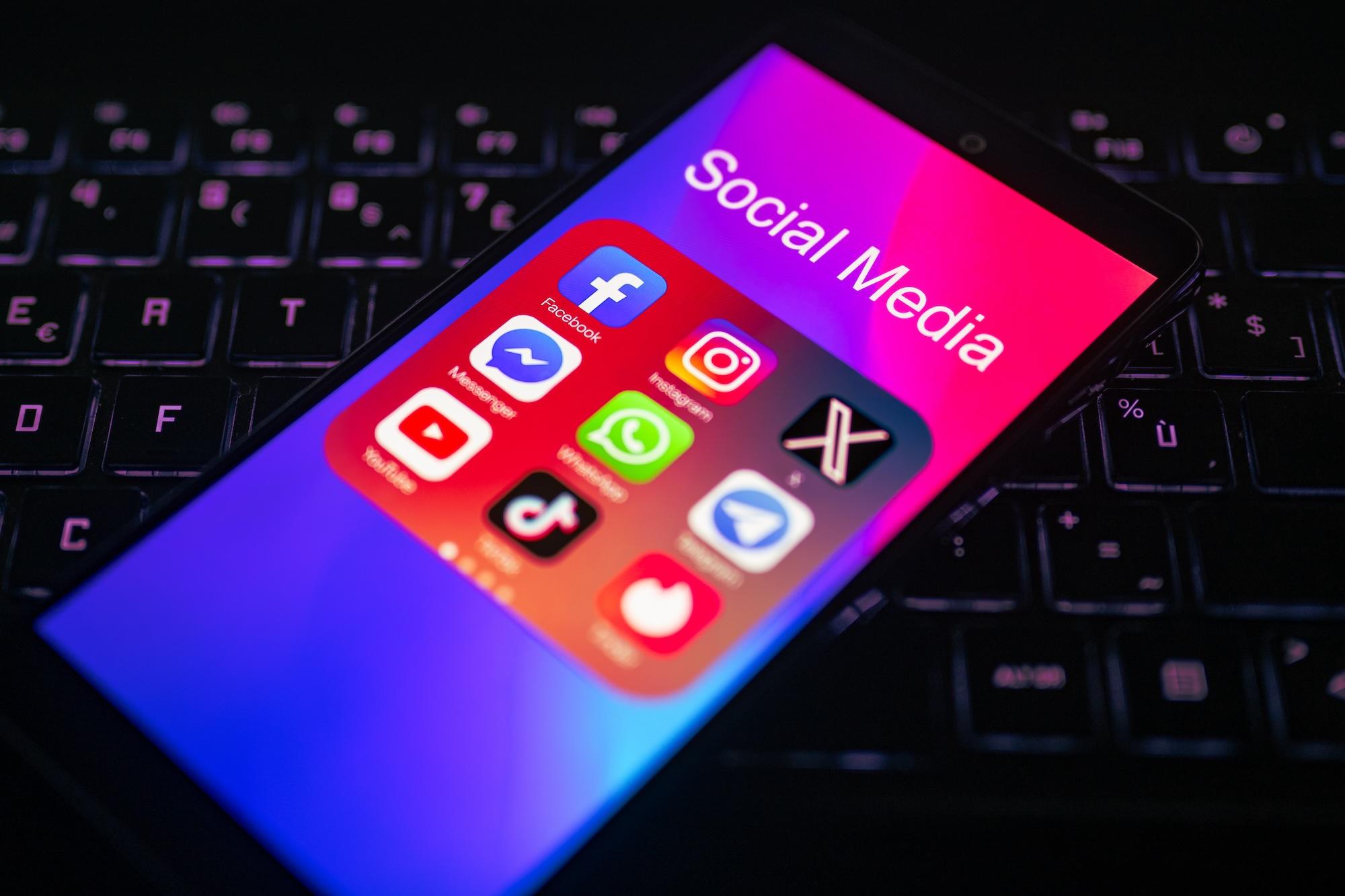 A close-up of the Facebook mobile app is being displayed on a smartphone screen next to those of TikTok, Telegram, Instagram, X, YouTube, and Messenger