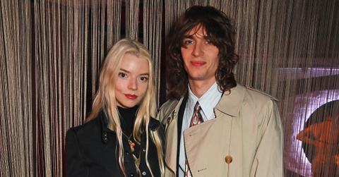 Anya Taylor-Joy in black with husband Malcolm McRae in trench coat and suit and tie in London in March 2024 at "Cabaret At The Kit Kat Club"