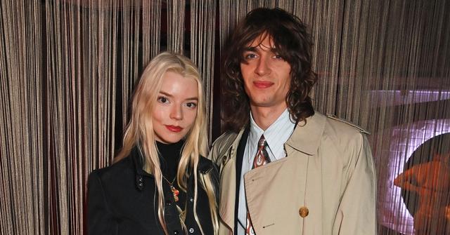 Anya Taylor-Joy in black with husband Malcolm McRae in trench coat and suit and tie in London in March 2024 at "Cabaret At The Kit Kat Club"