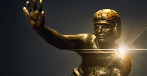 An image of the Heisman Trophy with a light behind it.