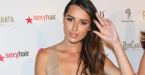 Kristina Kelly brushes her hair to the side while posing for a photo at a red carpet event