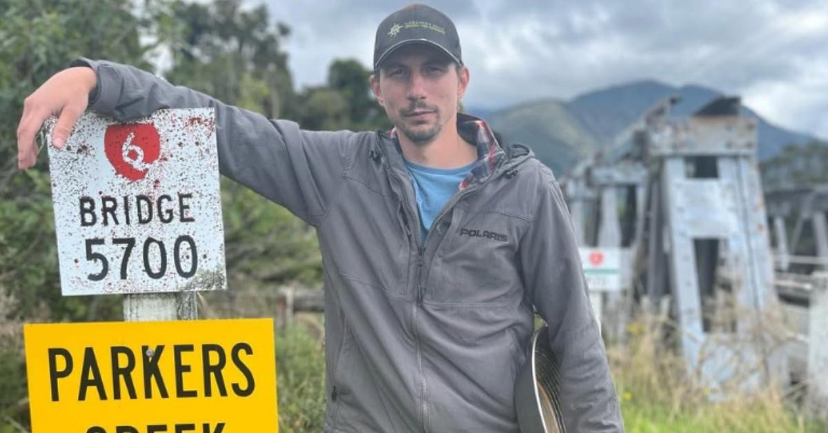 Parker Schnabel standing next to a Parkers Creek sign.