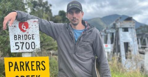 Parker Schnabel standing next to a Parkers Creek sign.