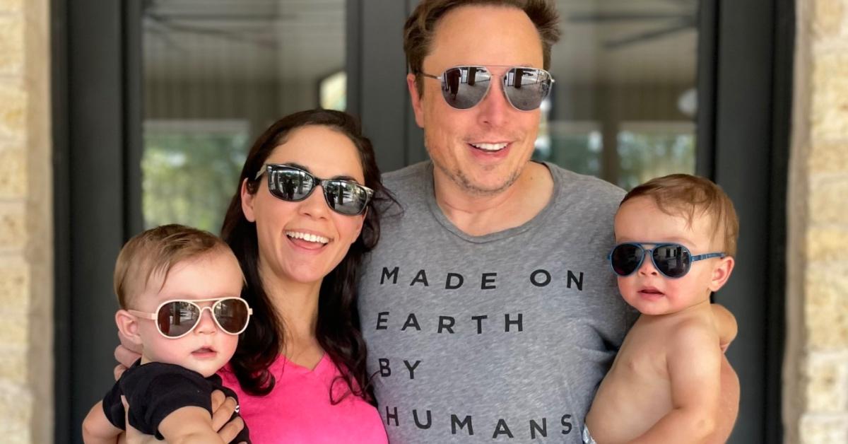 Elon Musk and Shivon Zilis holding two of their kids.