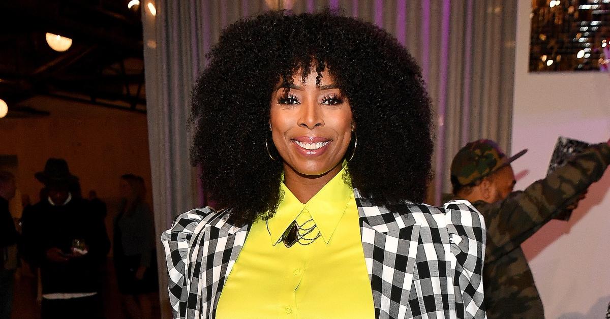 Actress Tasha Smith smiling and wearing a bright yellow button-down shirt and black and white blazer at UTA's cocktail reception in Atlanta. 