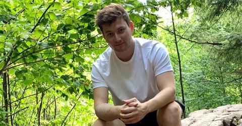 Bajan Canadian sitting on a rock.