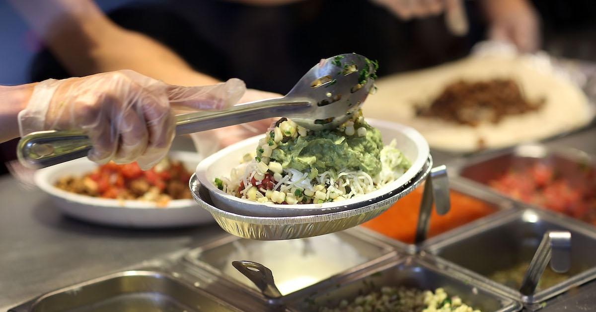 A Chipotle worker fulfilling a bowl order