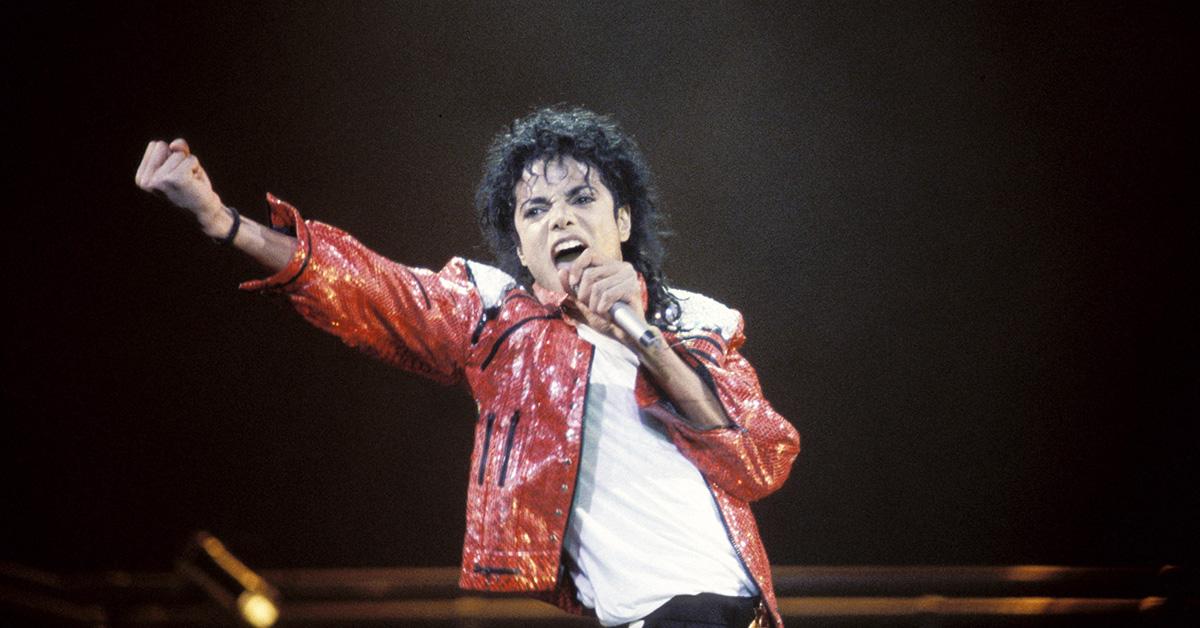 Michael Jackson performing on stage in his red jacket. 