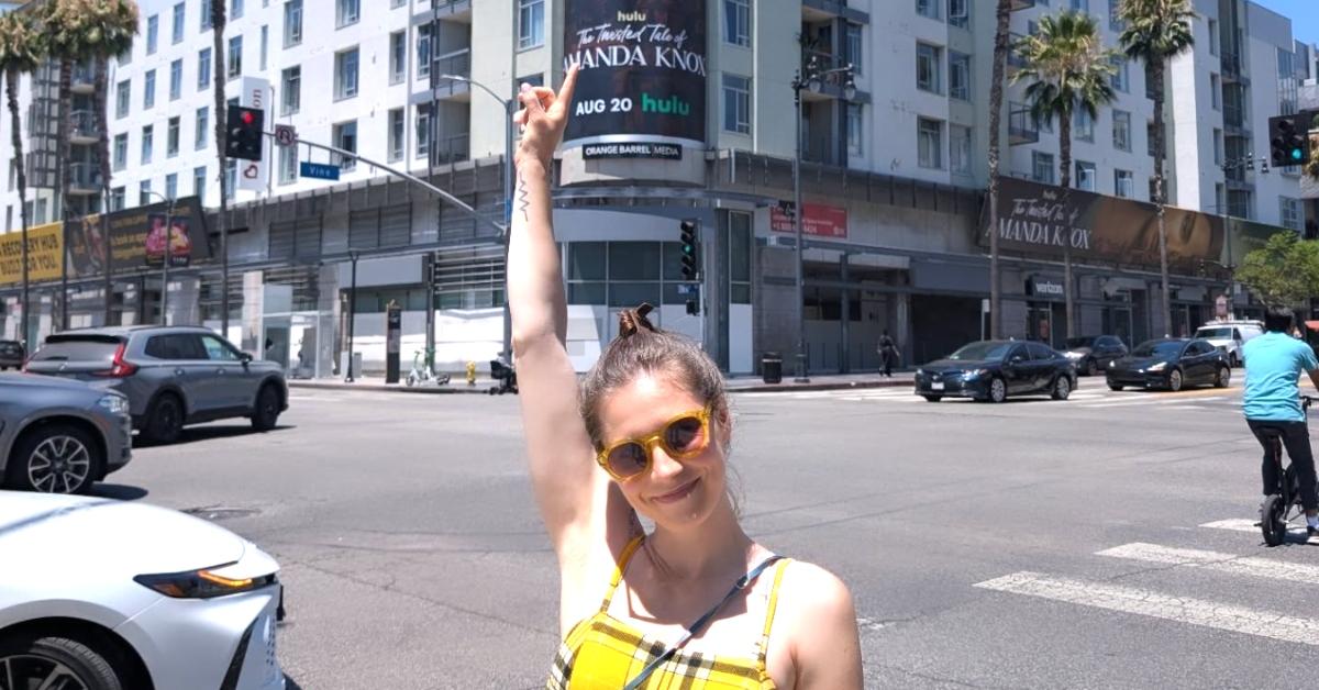 Amanda Knox points to a billboard advertising her Hulu series