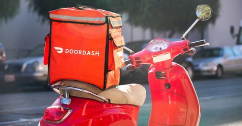 A scooter with a DoorDash delivery bag on the seat.