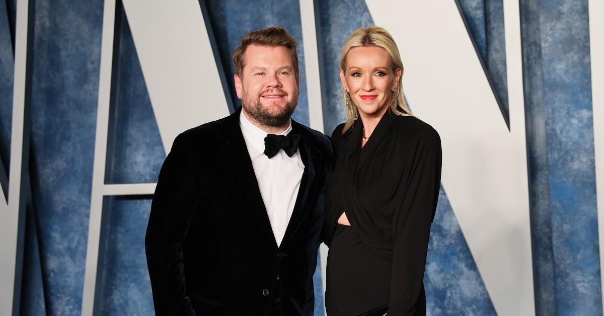 (L-R) James Corden, in a black tux, stands arm in arm with his wife, Julia Carey, at the 2023 Vanity Fair Oscars party.