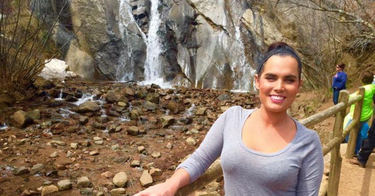 Sara Livelsberger on a hike with a waterfall behind her. 