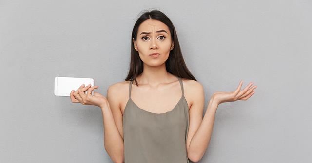 Confused woman holding smartphone