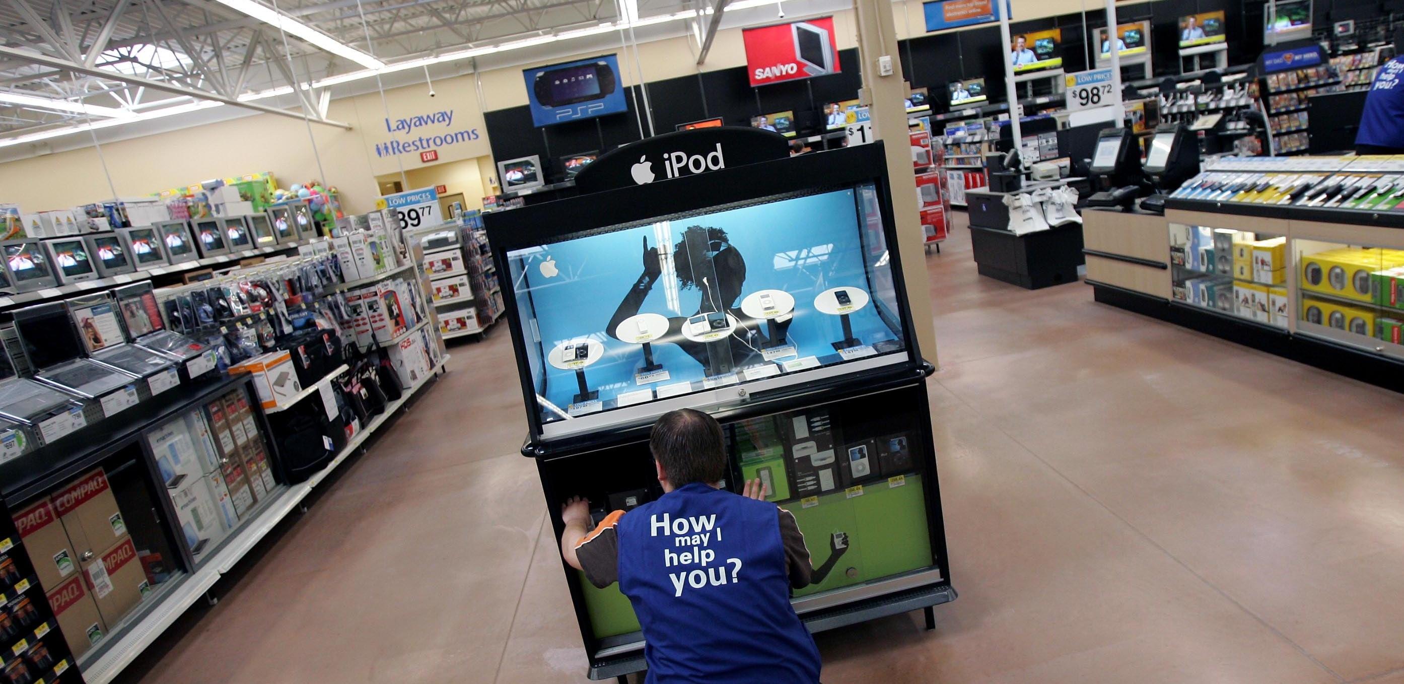 A Walmart employee restocking electronic items