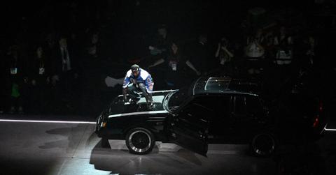 Kendrick Lamar standing on a car at the Super Bowl.