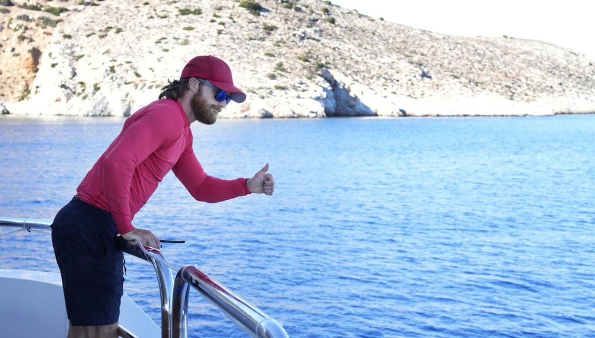 Iain Maclean holds a thumbs up over the railing of the Mustique.