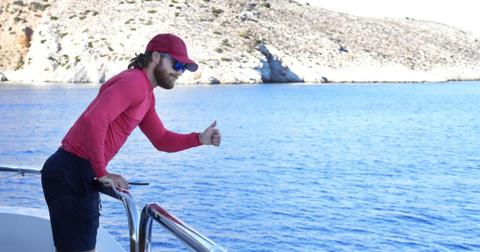 Iain Maclean holds a thumbs up over the railing of the Mustique.