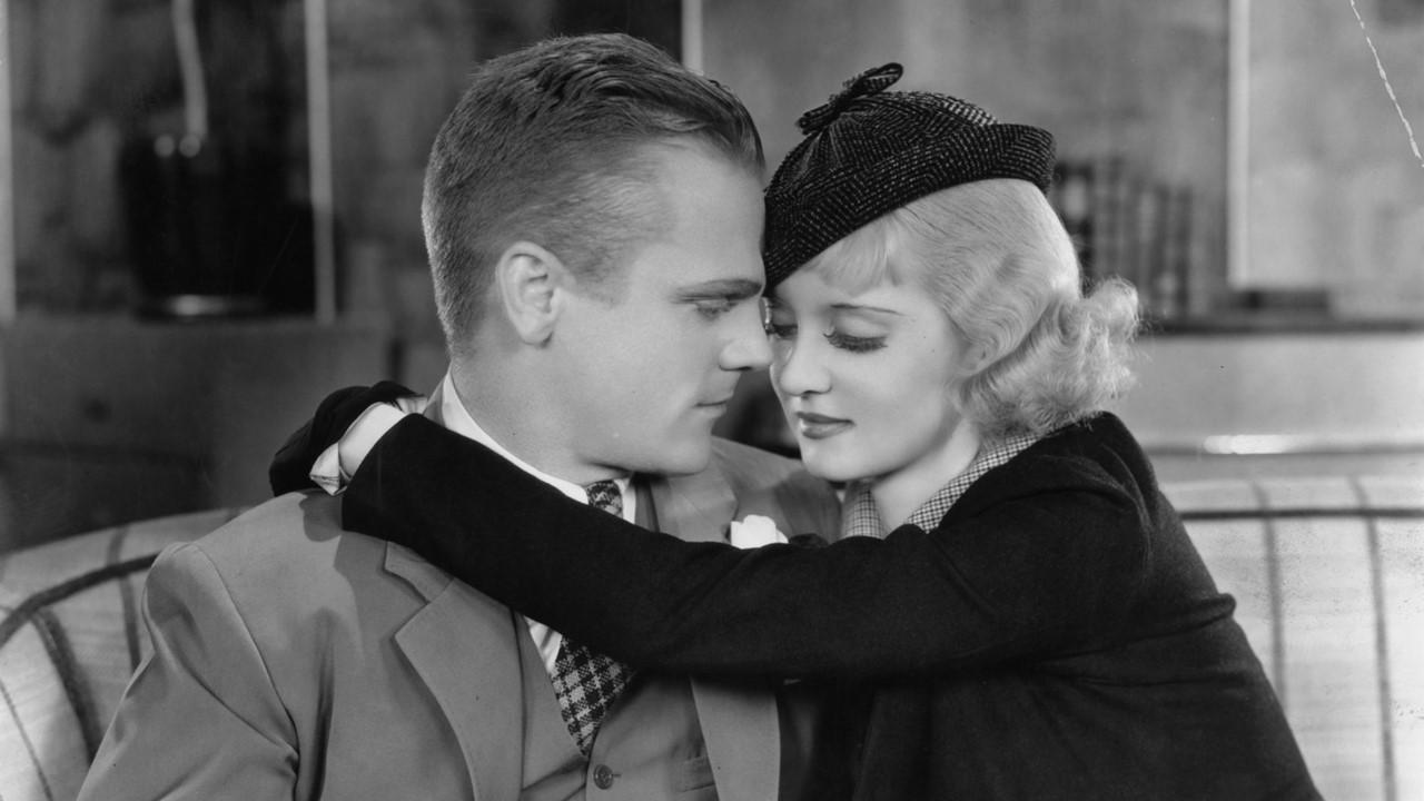 James Cagney getting a hug from Bette Davis in a scene from the film 'Jimmy The Gent' in 1934. 