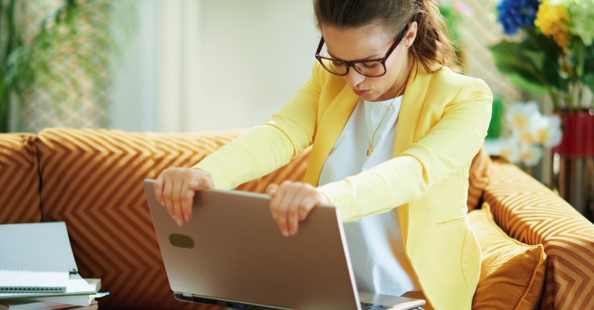 woman looks frustrated about to shut down her laptop