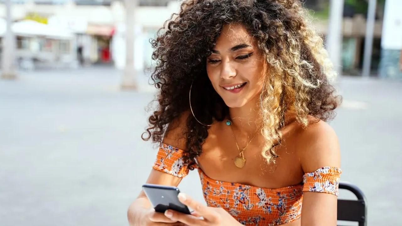 A woman looking at Facebook Dating on her cell phone