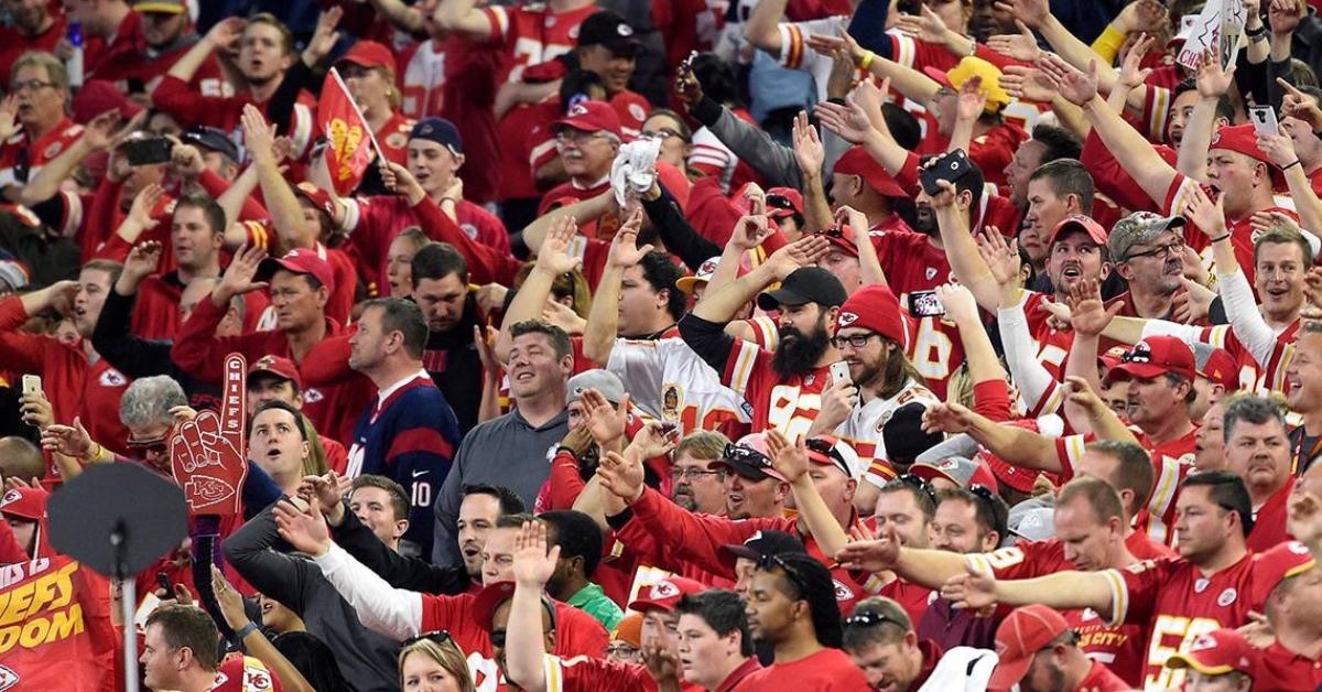 Kansas City Chiefs fans performing the "Tomahawk Chop" in the audience.