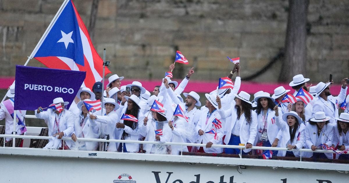 PARIS, FRANCE - JULY 26: Athletes from Puerto Rico delegation sail in a boat along the river Seine as rain starts at the start of the opening ceremony of the Paris 2024 Olympic Games in Paris, France on July 26, 2024. (Photo by Aytac Unal/Anadolu via Getty Images)